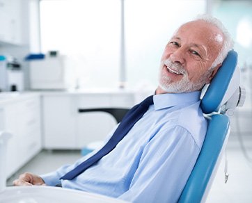Senior man in suit sitting in dental chair