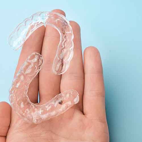 Holding two clear aligners in Fort Worth, TX in a single hand