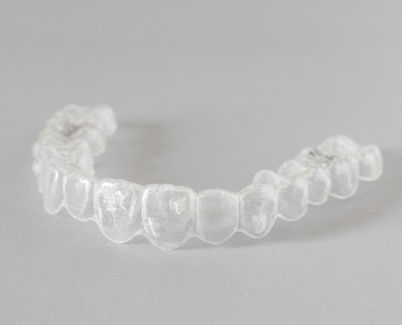 ClearCorrect clear aligner in Fort Worth, TX on a grey background