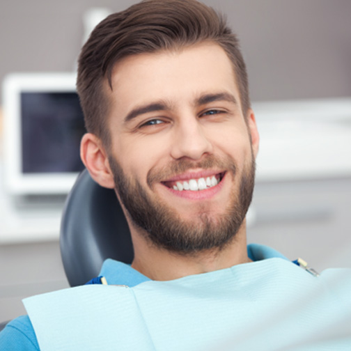 Close-up of smiling male patient in dental chair
