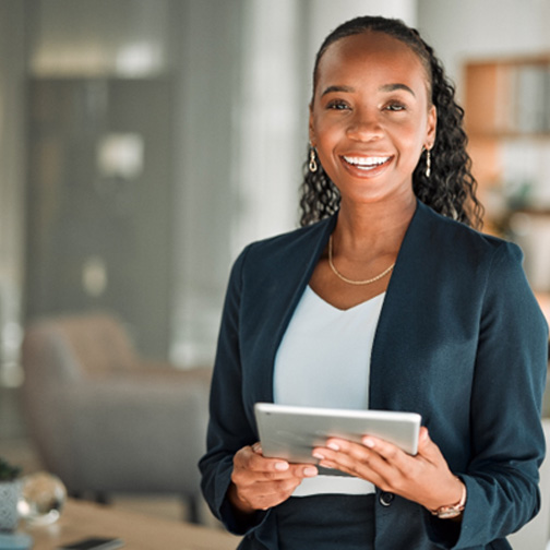 Woman in business suit smiling and holding tablet